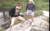 Two girls peeing under a bridge