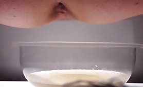 Mature man peeing into a plastic bowl