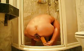 Man shitting in shower while holding turd and pissing