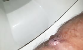 Man shitting hard into toilet, long brown turd drops fast