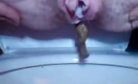 Chubby girl pissing over the toilet with white leak
