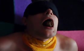 Man sucking a brown turd with blindfold on