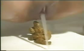 Brunette girl shitting a big turd on the floor