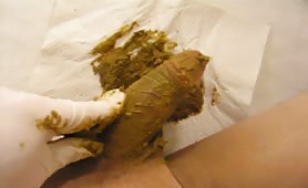 Man smearing fresh shit on his cock with gloved hand