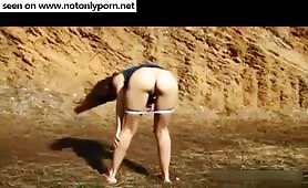 Brunette girl shitting outdoors in top and thong
