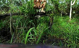 Man shitting outdoors on a log in the grass