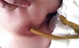 Guy shitting long brown turd into his mouth