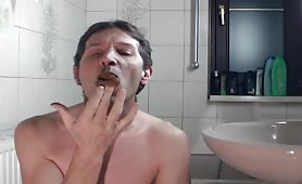 Man smearing shit on his face and cock in bathroom