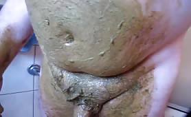 Fat man washing scat off his body in shower