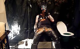 Mature man smears shit on his black leather outfit