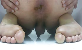 Man shitting long brown turd on white floor