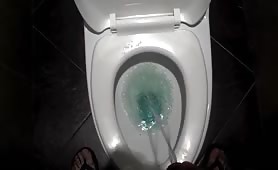Man shitting long yellow turd in toilet, pisses after
