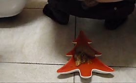 Man shitting on red Christmas tree plate