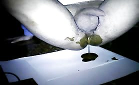 Naked guy shitting liquid crap on a white napkin