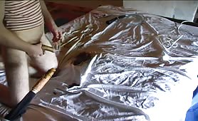 Man in shirt shitting on bed with bottle and dildo