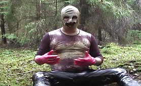 Man in mask shits and pisses in forest mud
