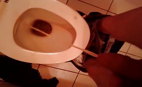Guy pissing in toilet with turd already inside