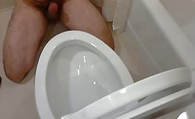 Man shitting and pissing in toilet bowl, eats from it