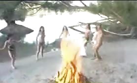 Two women shitting and pissing outdoors on sand