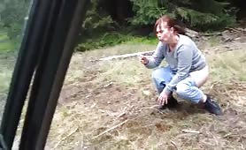 Woman shitting outdoors in shorts