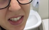 Woman shitting in shorts over toilet