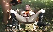 Woman shitting in a wheelbarrow outdoors