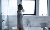 Blonde woman pissing in bathroom sink