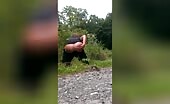 Woman squatting outdoors shitting on gravel path