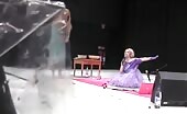 Blonde in dress shits while woman in purple sings