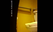 Phone in hand while squatting over toilet with pants down