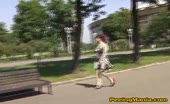 Woman pissing on park bench in patterned dress