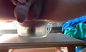 Man pissing into glass cup with turd inside